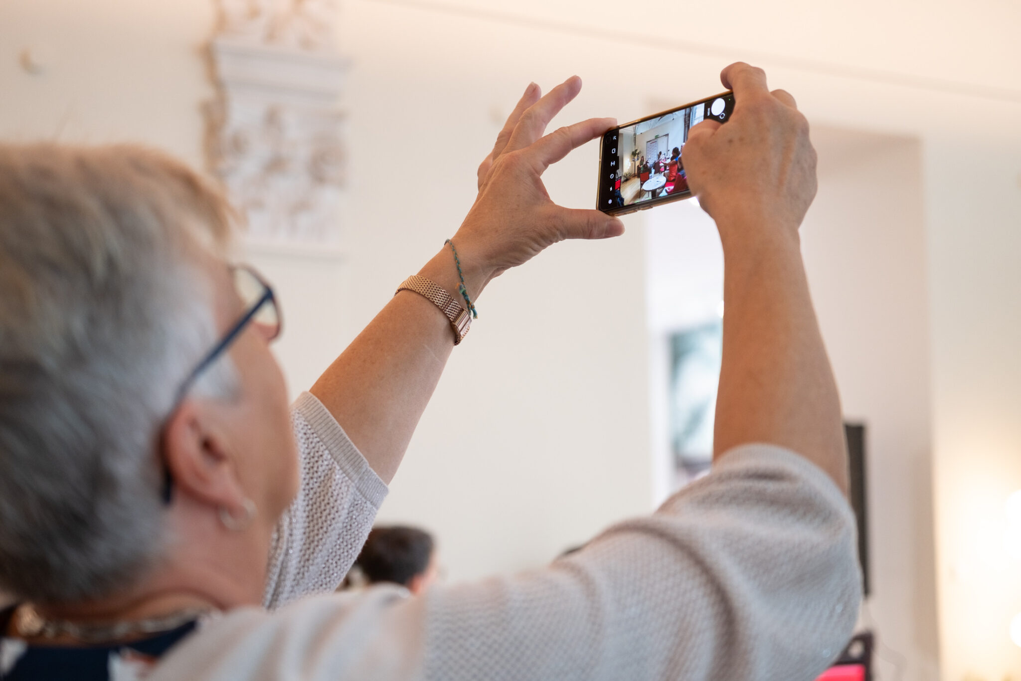 Ältere Person fotografiert Margarita Gressl mit dem Smartphone